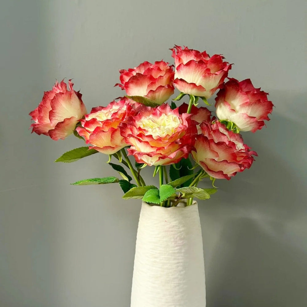 Arrangement of vibrant Apple Jack roses in white vase